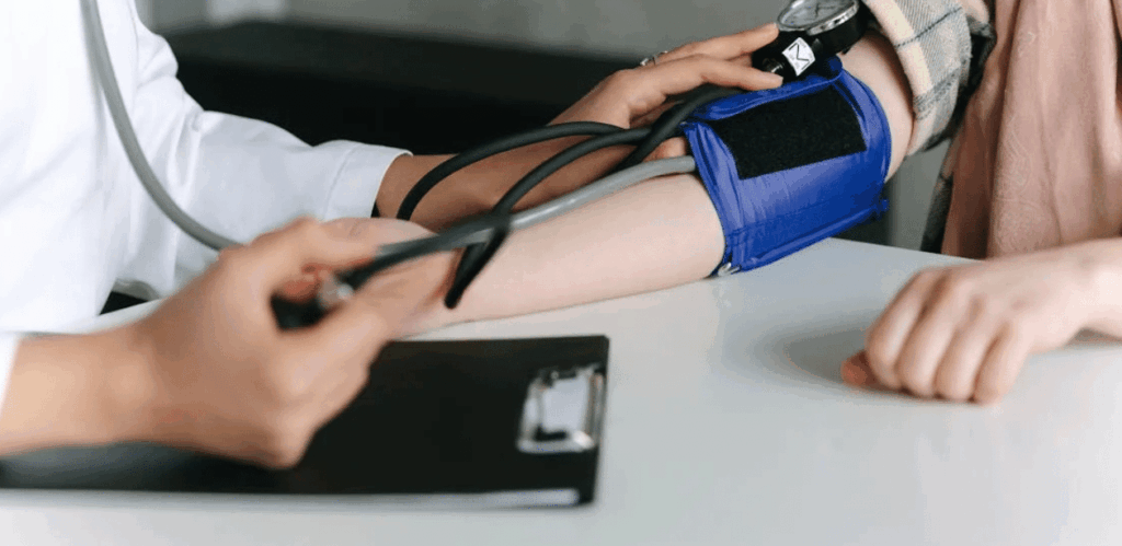 Médico verifica pressão arterial do paciente durante avaliação relacionada ao tratamento para hipertensão secundária.