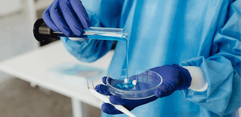 Pesquisador em laboratório manuseando substância em experimento com células-tronco para estudo de regeneração nervosa.