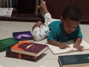 Criança com habilidades especiais sentadas em casa, interagindo com letras e números em diferentes idiomas.