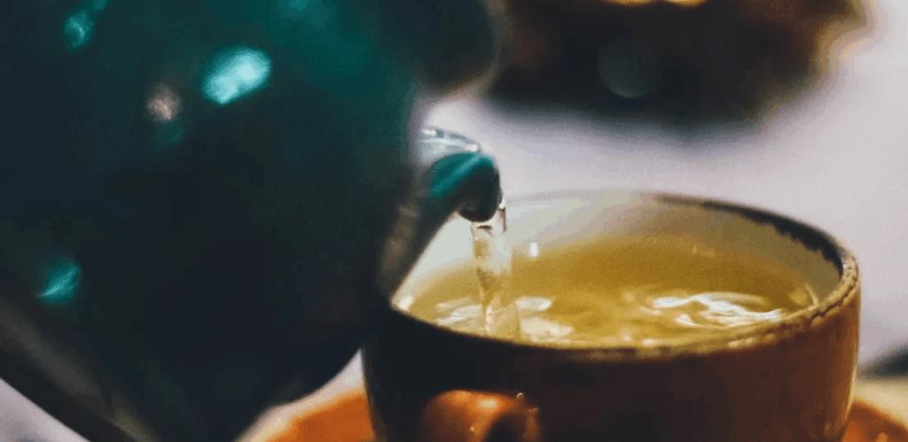 Xícara sendo preenchida com chá para desintoxicar o fígado de forma natural e auxiliar na saúde hepática