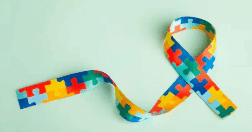 Laço colorido com peças de quebra-cabeça simboliza o autismo na vida adulta durante o Abril Azul