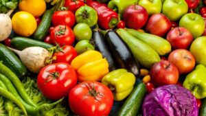 Comer frutas e vegetais melhora o sono Frutas e vegetais coloridos em uma mesa ao lado de uma cama reforçam como comer frutas e vegetais melhora o sono.